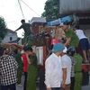 Lực lượng chức năng giúp di dời 80 hộ dân của huyện Nghi Sơn ra khỏi vùng nguy hiểm (Ảnh: TTXVN)