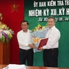 Ông Trần Cẩm Tú trao Quyết định và tặng hoa chúc mừng ông Trần Tiến Hưng. (Nguồn: Ủy ban Kiểm tra Trung ương)