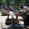 Người dân dâng hương lên các phần mộ tại Nghĩa trang Liệt sỹ Quốc gia Trường Sơn. (Ảnh: Nguyên Lý/TTXVN)