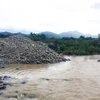Nhiều đống đá lớn đã được doanh nghiệp khai thác, tập kết đã cản trở dòng chảy của sông Dinh. (Ảnh: Công Thử/TTXVN)
