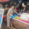 Chị Phan Thị Thúy Phượng (phải) tư vấn cho người tiêu dùng về túi nylon tự hủy sinh học tại chợ Gò Vấp. (Ảnh: Mỹ Phương/TTXVN)