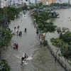 Nước ngập sâu trên đường Trần Xuân Soạn, quận 7, gây khó khăn trong việc đi lại và sinh hoạt của người dân. (Ảnh: Trần Xuân Tình/TTXVN)