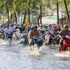 Triều cường gây ngập sâu trên đường Mậu Thân, quận Ninh Kiều khiến việc đi lại của người dân gặp khó khăn. (Ảnh: Thanh Liêm/TTXVN)