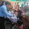 Công sứ Lại Xuân Chiến trao quà cho bà con. (Ảnh: Phóng viên TTXVN tại Campuchia)