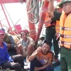 Cán bộ, chiến sỹ biên phòng Quảng Bình trò chuyện, thăm hỏi tình hình các thuyền viên tàu bị nạn. (Ảnh: Châu Thành/TTXVN)