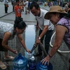 Người dân lấy nước sạch về sử dụng. (Nguồn: Vietnam+)