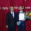 Thủ tướng Nguyễn Xuân Phúc chúc mừng phó giáo sư-tiến sỹ Bùi Nhật Quang. (Ảnh: Thống Nhất/TTXVN)