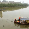 Công nhân thuộc Trung tâm ứng phó sự cố môi trường Việt Nam (SOS) làm sạch các khu vực bị ảnh hưởng sự cố tràn dầu. (Ảnh: An Đăng/TTXVN)