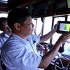 Cán bộ ngành thủy sản kiểm tra thiết bị giám sát hành trình khai thác trên tàu cá trước khi ra khơi, tại cảng cá Quy Nhơn, thành phố Quy Nhơn. (Ảnh: TTXVN)