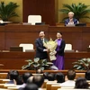 Chủ tịch Quốc hội Nguyễn Thị Kim Ngân tặng hoa cho ông Nguyễn Khắc Định. (Ảnh: Dương Giang/TTXVN)