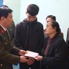 Đại tá Đào Đức Minh, Phó Giám đốc Công an tỉnh Thanh Hóa trao quà cho thân nhân gia đình các liệt sỹ. (Ảnh: Trịnh Duy Hưng/TTXVN)