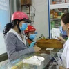 Nhân viên nhà thuốc tặng khẩu trang y tế cho người dân, chiều 31/1. (Ảnh: Phan Sáu/TTXVN)