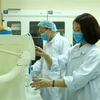 Cán bộ Viện Môi trường, Trường Đại học Hàng hải Việt Nam điều chế nước rửa tay khô phòng chống dịch bệnh do nCoV. (Ảnh: Minh Thu/TTXVN)