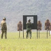 Các chuyên gia và học viên trình diễn kỹ năng bắn súng. (Ảnh: Dương Giang/TTXVN)
