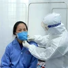 Bác sỹ Đội cơ động Bệnh viện Bạch Mai (Hà Nội) thăm khám cho bệnh nhân dương tính với virus corona chủng mới tại Trung tâm y tế huyện Bình Xuyên, Vĩnh Phúc. (Ảnh: Hoàng Hùng/TTXVN)