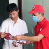 Hội viên Hội Chữ thập Đỏ thành phố Đà Nẵng đến tận nhà dân phát tờ rơi tuyên truyền và xà phòng miễn phí. (Ảnh: Văn Dũng/TTXVN)