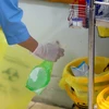Nhân viên y tế Trung tâm y tế huyện Bình Xuyên xịt dung dịch sát khuẩn vào thùng lưu chứa chất thải trước khi để vào nơi quy định. (Ảnh: Hoàng Hùng/TTXVN)