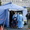 Nhân viên y tế hỗ trợ bệnh nhân nghi nhiễm COVID-19 tại khu cách ly của một bệnh viện ở Cremona, miền Bắc Italy ngày 4/3/2020. (Ảnh: AFP/TTXVN)
