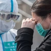 Bệnh nhân nhiễm COVID-19 tạm biệt bác sỹ sau khi được chữa khỏi tại bệnh viện ở Vũ Hán, tỉnh Hồ Bắc, Trung Quốc, ngày 10/3/2020. (Ảnh: THX/TTXVN)