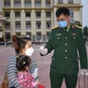 Kiểm tra thân nhiệt công dân tại Trung tâm Giáo dục quốc phòng Trường Quân sự Bộ Tư lệnh Thủ đô Hà Nội. (Ảnh: Nguyễn Cúc/TTXVN)