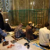 Các tín đồ Hồi giáo cầu nguyện bên ngoài đền thờ Fatima Masumeh ở thành phố Qom (Iran) sau khi đền thờ này đóng cửa do dịch COVID-19 ngày 16/3/2020. (Ảnh: AFP/TTXVN)