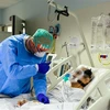 Nhân viên y tế động viên một bệnh nhân mắc COVID-19 tại một bệnh viện ở Bergamo, Italy ngày 3/4/2020. (Ảnh: AFP/TTXVN)
