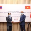 Thứ trưởng Ngoại giao Nguyễn Quốc Dũng (bên phải) trao biểu trưng thiết bị y tế cho Đại sứ Lào tại Việt Nam Sengphet Houngboungnuang. (Ảnh: Dương Giang/TTXVN)