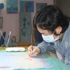 Họa sỹ Phan Tuấn Ngọc vẽ tranh với chủ đề 'Hãy ở nhà.' (Ảnh: Thùy Dung/TTXVN)