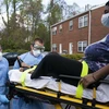 Nhân viên y tế chuyển bệnh nhân mắc COVID-19 lên xe cứu thương tại Glen Burnie, bang Maryland, Mỹ ngày 21/4/2020. (Ảnh: AFP/TTXVN)