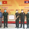 Đại diện lãnh đạo Bộ Tư lệnh Quân khu 4 (bên trái) trao tặng vật tư y tế cho đại diện quân đội Lào. (Ảnh: TTXVN)