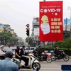 Tranh cổ động tuyên truyền về COVID-19 được đặt ở các điểm nút giao thông của Hà Nội. (Ảnh: Thanh Tùng/TTXVN)