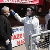 Nhân viên y tế kiểm tra thân nhiệt người dân tại một khu chợ ở Ankara, Thổ Nhĩ Kỳ nhằm ngăn chặn sự lây lan của dịch COVID-19 ngày 17/4/2020. (Ảnh: THX/TTXVN)