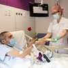 Nhân viên y tế tặng hoa hồng và sách cho bệnh nhân nhiễm COVID-19 tại bệnh viện ở Barcelona, Tây Ban Nha, ngày 23/4/2020. (Ảnh: THX/TTXVN)