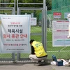 Nhân viên dỡ tấm biển đóng cửa tạm thời do dịch COVID-19 tại một sân bóng đá ở Seoul, Hàn Quốc, ngày 4/5/2020. (Ảnh: Yonhap/TTXVN)