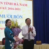 Ông Phạm Sỹ Lợi, Chủ tịch HĐND tỉnh Hà Nam tặng hoa chúc mừng bà Đinh Thị Lụa. (Ảnh: Thanh Tuấn/TTXVN)