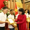 Phó Chủ tịch nước Đặng Thị Ngọc Thịnh tặng ảnh chân dung Chủ tịch Hồ Chí Minh cho các gia đình tiêu biểu năm 2020. (Ảnh: Dương Giang/TTXVN)