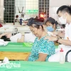 Các nhân viên y tế của Phòng Chẩn trị y học cổ truyền Thiên An thuộc Dòng trợ thế Thánh Gioan Thiên Chúa đang điều trị cho bệnh nhân. (Nguồn: Báo Đồng Nai)
