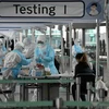 Nhân viên y tế lấy mẫu dịch xét nghiệm COVID-19 cho hành khách tại sân bay quốc tế Incheon, phía tây thủ đô Seoul, Hàn Quốc. (Ảnh: AFP/TTXVN)