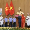 Thủ tướng Nguyễn Xuân Phúc gắn Huân chương Hồ Chí Minh lên lá cờ truyền thống của Viện Kiểm sát Nhân dân Tối cao. (Ảnh: Doãn Tấn/TTXVN)