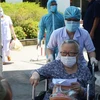Y bác sỹ Bệnh viện C Đà Nẵng dìu bệnh nhân ra cổng để trở về nhà sau thời gian điều trị trong tình trạng bệnh viện bị cách ly. (Ảnh: Văn Dũng/TTXVN)
