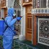 Nhân viên y tế phun thuốc khử trùng nhằm ngăn chặn sự lây lan của dịch COVID-19 tại một nhà thờ ở Amman, Jordan. (Ảnh: AFP/TTXVN)