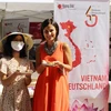 Phó Thị trưởng thành phố Augsburg, bà Martina Wild (áo dài cam), ấn tượng với ẩm thực của Việt Nam. (Ảnh: TTXVN phát)