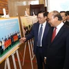 Thủ tướng Nguyễn Xuân Phúc cùng các đại biểu tham quan triển lãm ảnh về kết quả phong trào thi đua yêu nước giai đoạn 2015-2020. (Ảnh: Văn Điệp/TTXVN)