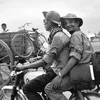 Phóng viên TTXGP Nguyễn Đức Giáp (người ngồi sau) cùng đồng nghiệp trên đường tiến về Sài Gòn trong chiến dịch Hồ Chí Minh, tháng 4/1975. (Ảnh: Tư liệu TTXGP)