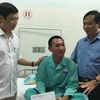 Chủ tịch UBND tỉnh Quảng Trị Võ Văn Hưng (áo xanh) thăm hỏi, tặng quà các thuyền viên và ngư dân bị nạn. (Ảnh: Hồ Cầu/TTXVN)