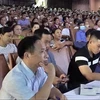 Phóng viên Phạm Văn Hướng ngồi ghi chép cuộc đối thoại giữa lãnh đạo tỉnh với người dân ngày 5/10. (Nguồn: Báo Thanh Niên)