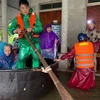 Công an huyện Thạch Hà, tỉnh Hà Tĩnh cùng chính quyền địa phương hỗ trợ đưa người dân đi sơ tán. (Ảnh: TTXVN phát)