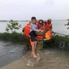 Lực lượng công an huyện Thạch Hà, tỉnh Hà Tĩnh sơ tán người già, trẻ em đến nơi an toàn. (Ảnh: TTXVN phát)