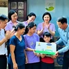 Ông Ngô Công Thắng - Giám đốc Nhà máy sữa Vinamilk Nghệ An đại diện công ty và Quỹ sữa Vươn cao Việt Nam thăm hỏi gia đình và trao tặng học bổng trị giá 50 triệu đồng để hỗ trợ chị em Đạt. (Nguồn: Vietnam+)