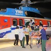 Hai bệnh nhân được đưa về đến Sân bay Tân Sơn Nhất, Thành phố Hồ Chí Minh tối 22/10. (Ảnh: TTXVN phát)
